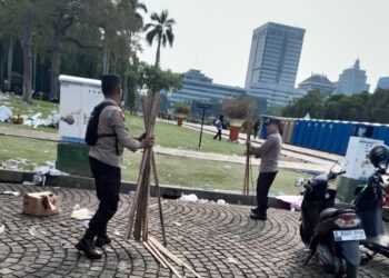 Personel Polri Sigap Bersih-bersih Kawasan Monas Usai May Day Fiesta