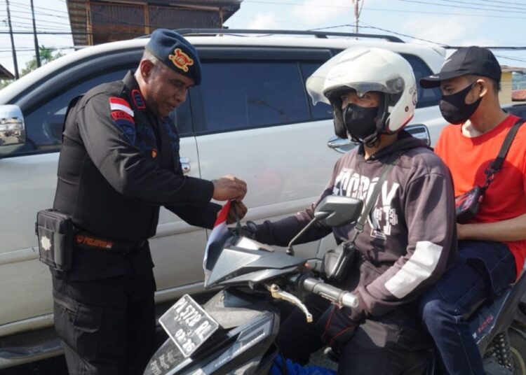 Satbrimob Polda Papua Pasang Dan Bagikan Bendera Merah Putih Ke Masyarakat
