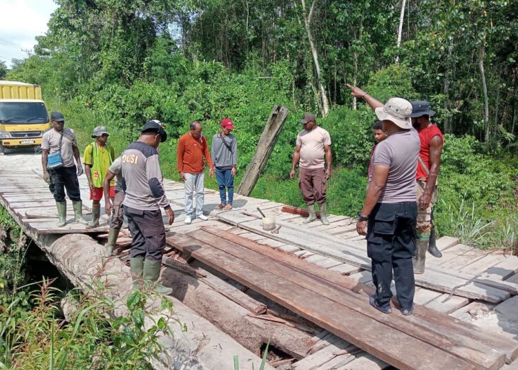 Kapolsek Bonggo Bersama Warga Perbaiki Jembatan Kayu di Kampung Mawes Mukti